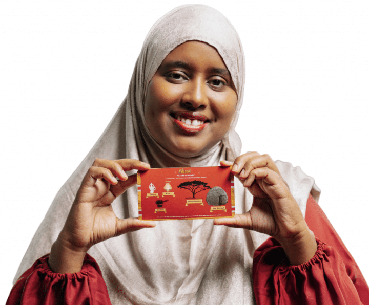 Smiling woman in cream hijab and red long sleeves holding up a card. The background is white.